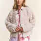 Stylish woman wearing a J.NNA mixed fabric chic jacket, showcasing a fashionable blend of textures and comfort.