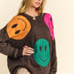 Fun oversized sweater with colorful smiley faces, perfect for a cozy and stylish casual look.