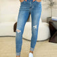 Woman wearing Mid Rise Destroy & Cuff Skinny Judy Blue Jeans with white sneakers