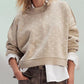 Woman wearing Bella Road Slit Round Neck Long Sleeve Sweater in beige, showcasing cozy and stylish fall fashion.