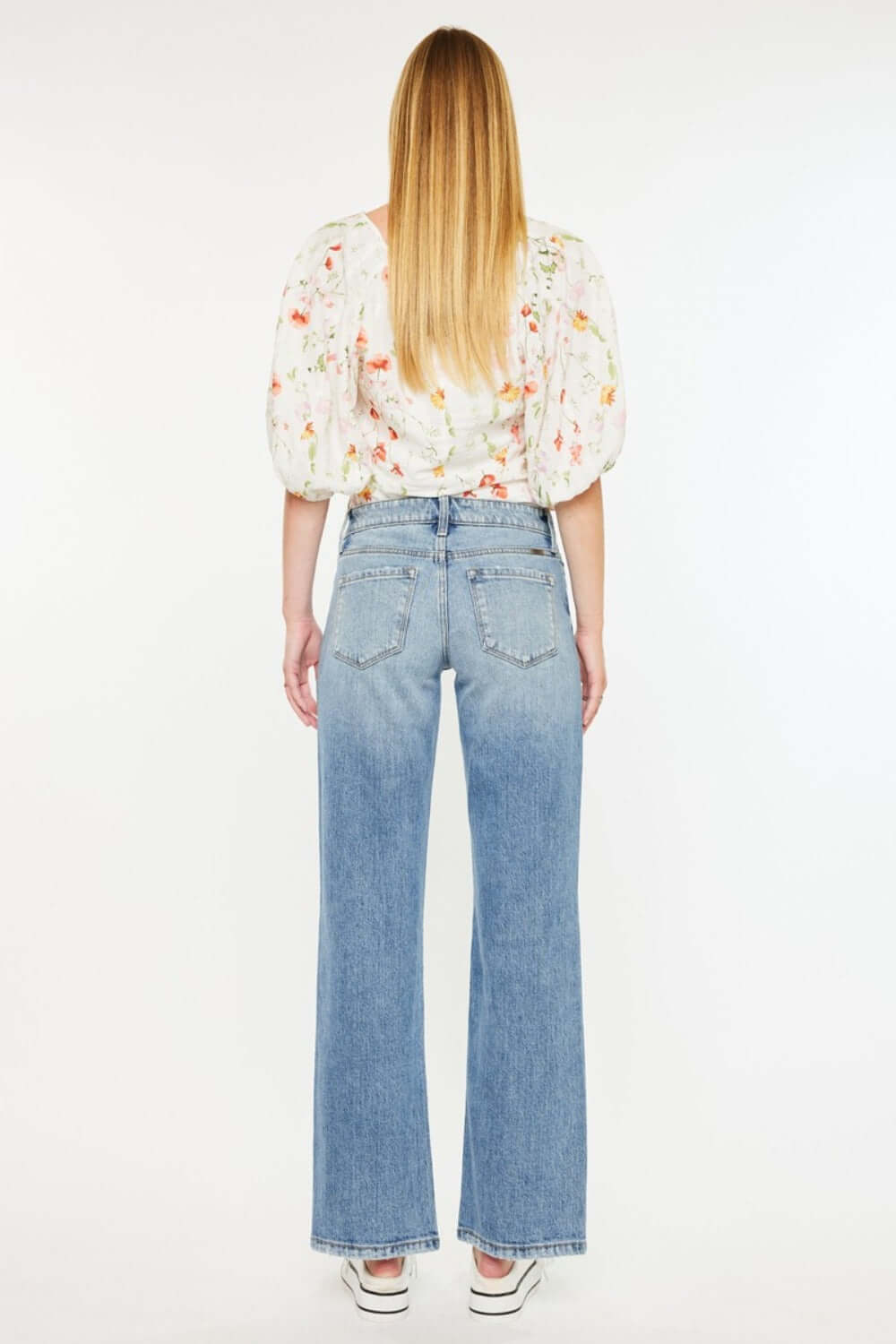 Back view of Kancan Mid Rise Frayed Hem Straight Jeans in medium wash denim paired with a floral blouse, highlighting trendy destroyed hem.