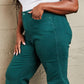 Woman wearing Hailey Full Size Tummy Control High Waisted Cropped Wide Leg Jeans in rich teal by Judy Blue Jeans.