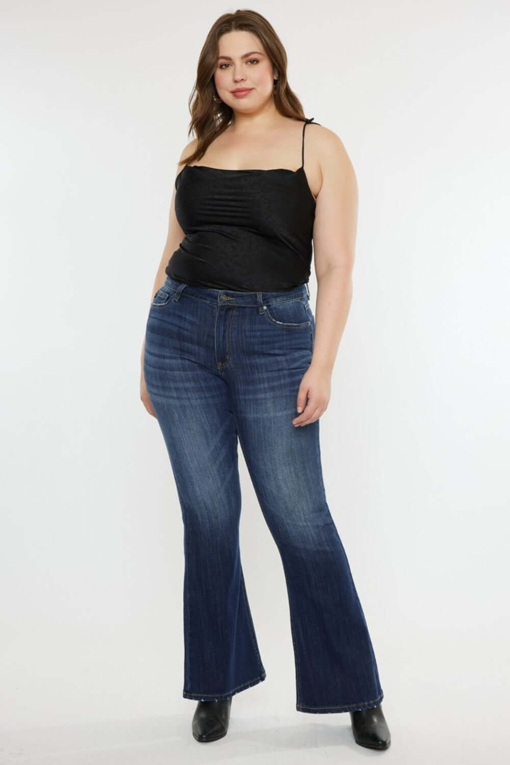 Woman wearing Kancan full size mid-rise slim flare jeans in dark stone wash, showcasing a chic and versatile style.