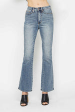 Plus size bootcut jeans with a high waist and a light wash, perfect for a stylish and comfortable fit.