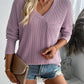 Woman wearing a Double Take Pocketed Textured V-Neck Long Sleeve T-Shirt in lavender with denim shorts and a clutch