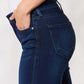 Woman wearing mid-rise flare jeans with a timeless silhouette and a non-distressed look, showcasing the pocket and stretch denim fabric.