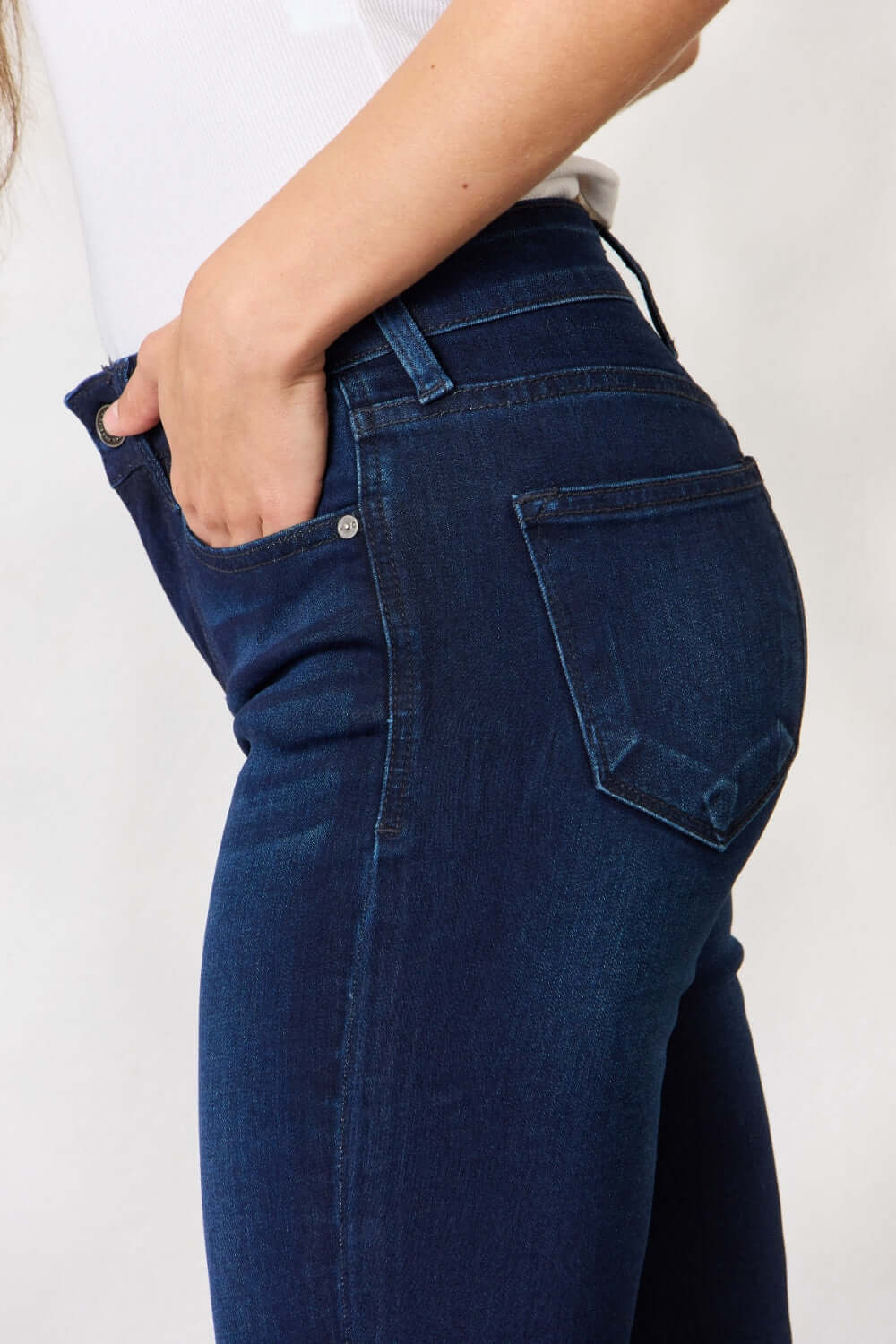 Woman wearing mid-rise flare jeans with a timeless silhouette and a non-distressed look, showcasing the pocket and stretch denim fabric.