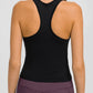 Back view of a woman wearing a black Millennia Round Neck Racerback Active Tank, showcasing comfort and sporty design.