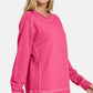 Model showcasing a pink Zenana Pigment Dyed French Terry Sweatshirt, perfect for casual wear and comfort.