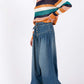 Woman wearing SAGE+FIG smocked waistband wide leg jeans for a trendy, relaxed look.