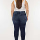 Back view of Cat's Whiskers Raw Hem High Waist Jeans showcasing edgy raw hem details, paired with a casual white top.