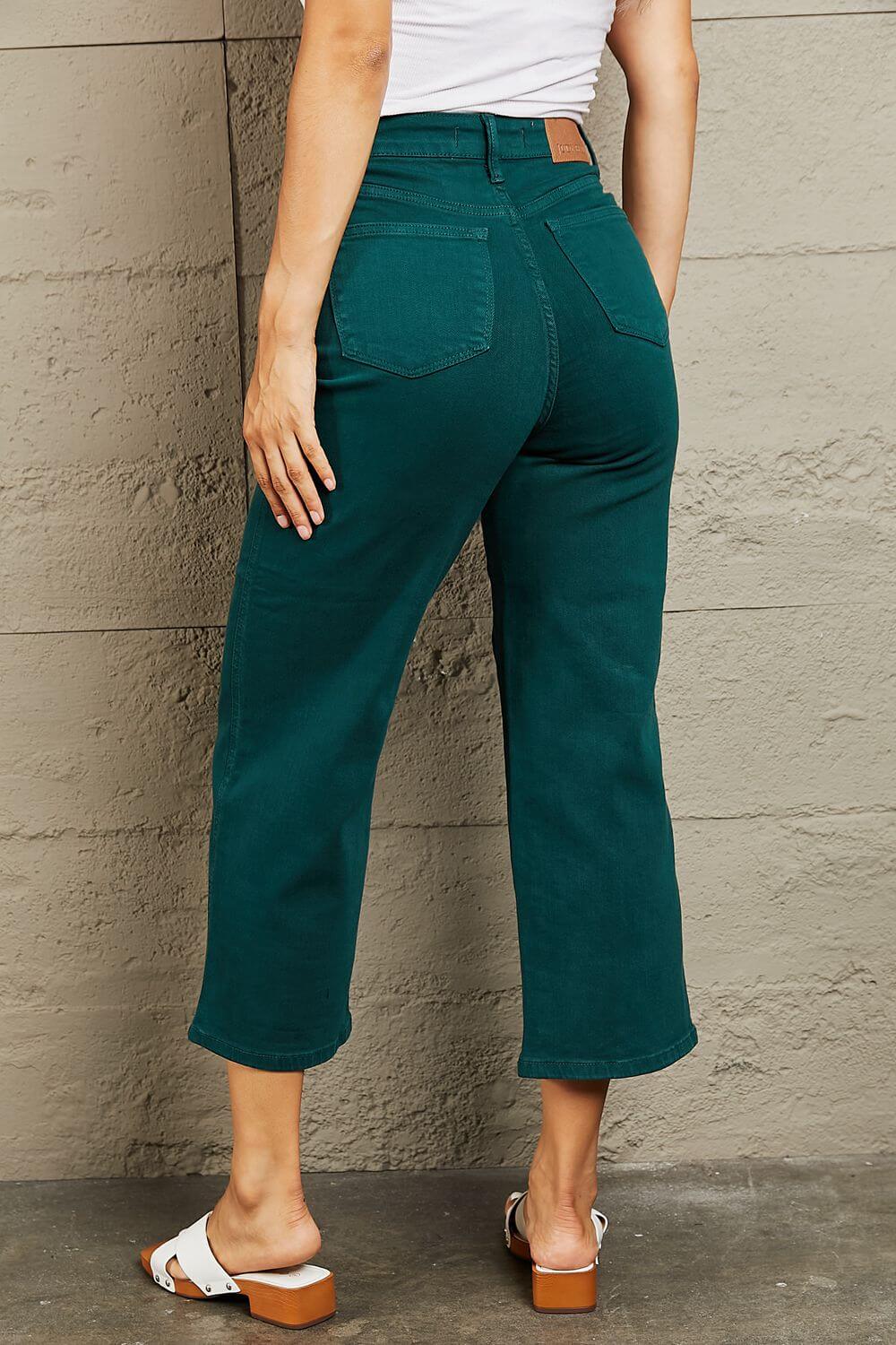 Woman wearing Judy Blue high waisted cropped wide leg jeans providing tummy control in teal, showcasing the back view.