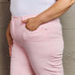 Woman wearing Raelene High Waist Wide Leg Jeans in Light Pink by Risen Jeans, showcasing chic and comfortable fit.