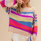 Woman wearing BiBi Multi Color Geometric Stripe Sweater, showcasing vibrant and trendy design, perfect for cozy, chic style.