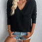 Woman wearing Double Take Pocketed Textured V-Neck Long Sleeve T-Shirt in black with denim shorts.