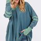 Woman wearing Mineral Wash Side Slit Contrast T-Shirt with V-neck, long sleeves, stitchy sewing, and band accents in casual style.