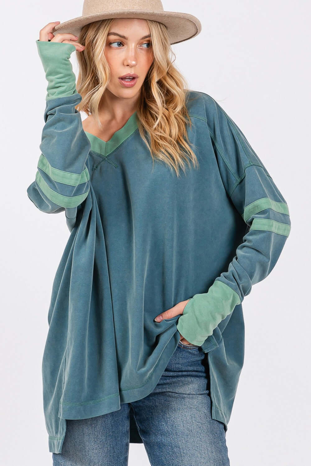 Woman wearing Mineral Wash Side Slit Contrast T-Shirt with V-neck, long sleeves, stitchy sewing, and band accents in casual style.