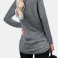 Woman wearing Bella Road Round Neck Long Sleeve T-Shirt in gray, back view showing long blonde hair and black pants.