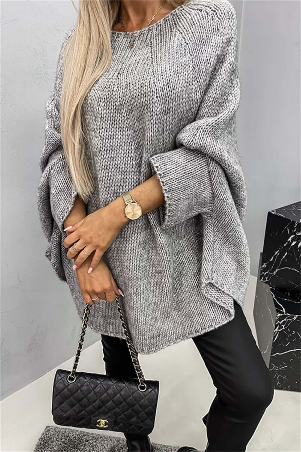 Cozy Bella Road round neck batwing sleeve sweater in gray paired with black pants and stylish handbag.