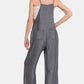 Woman wearing washed adjustable strap wide leg denim overalls, showcasing a trendy and comfortable style from the back.