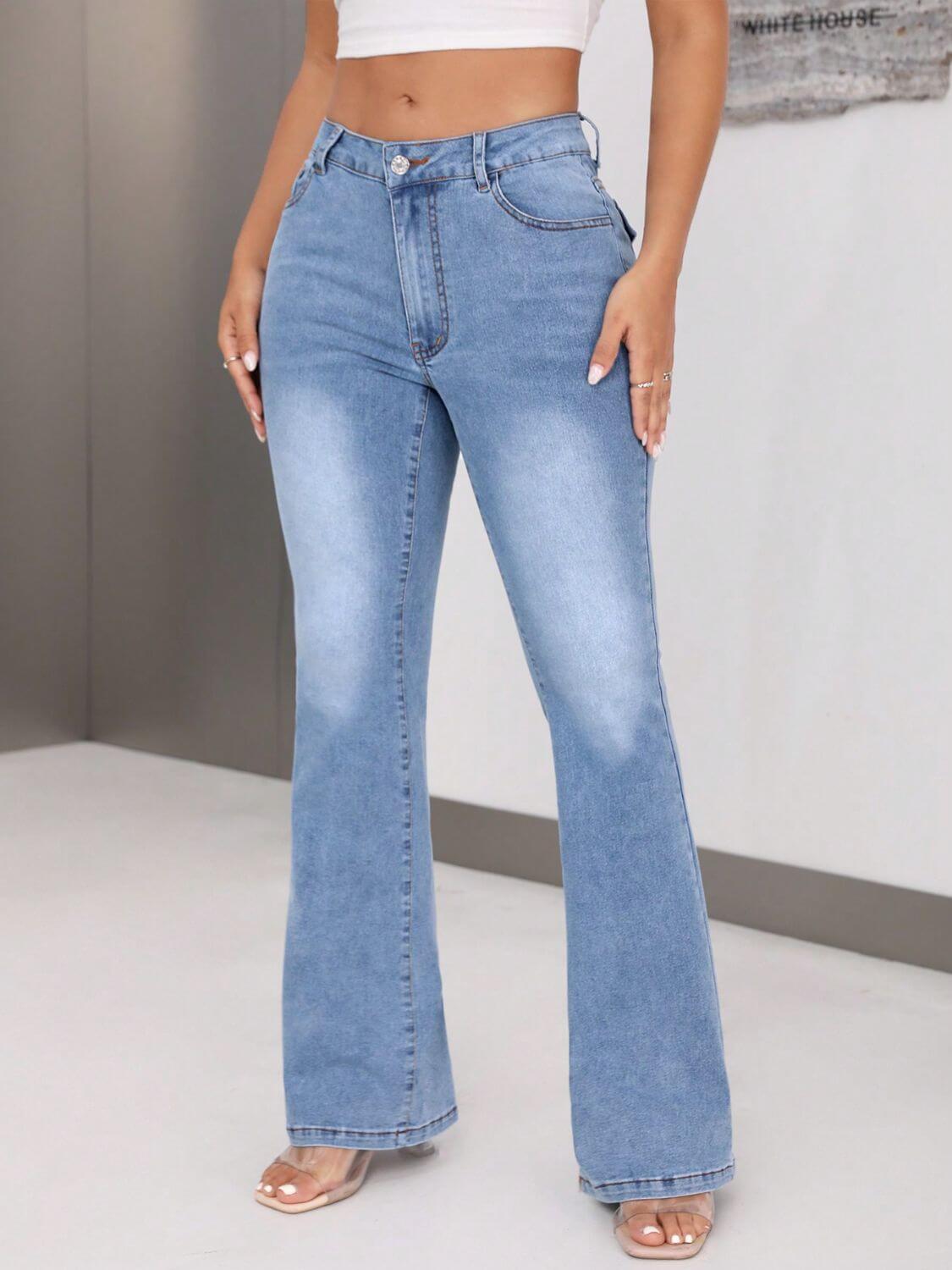 Woman wearing bootcut jeans with pockets in light blue denim, buttoned at the waist, and highly stretchy, paired with a white top.