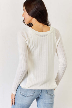 Woman wearing a fitted long sleeve cutout top with a tank top interior and a shrug-style pullover, showcasing the back draping effect.