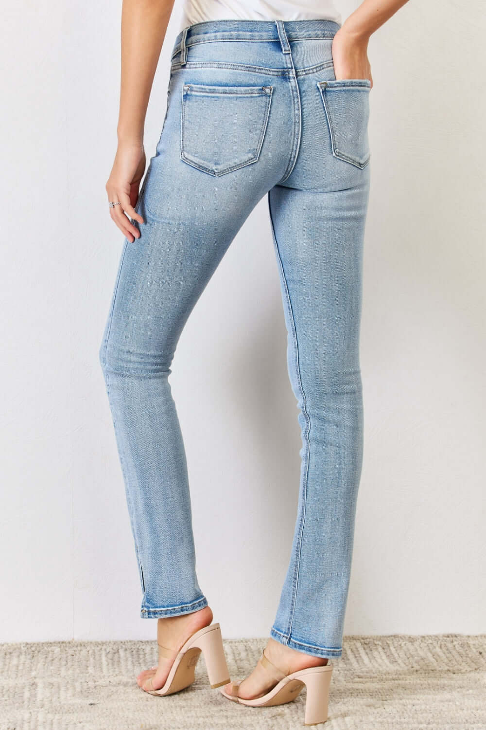 Mid Rise Y2K Slit Bootcut Jeans showcasing rear view with sleek side slit detail, light wash, and pocketed design for style and comfort.