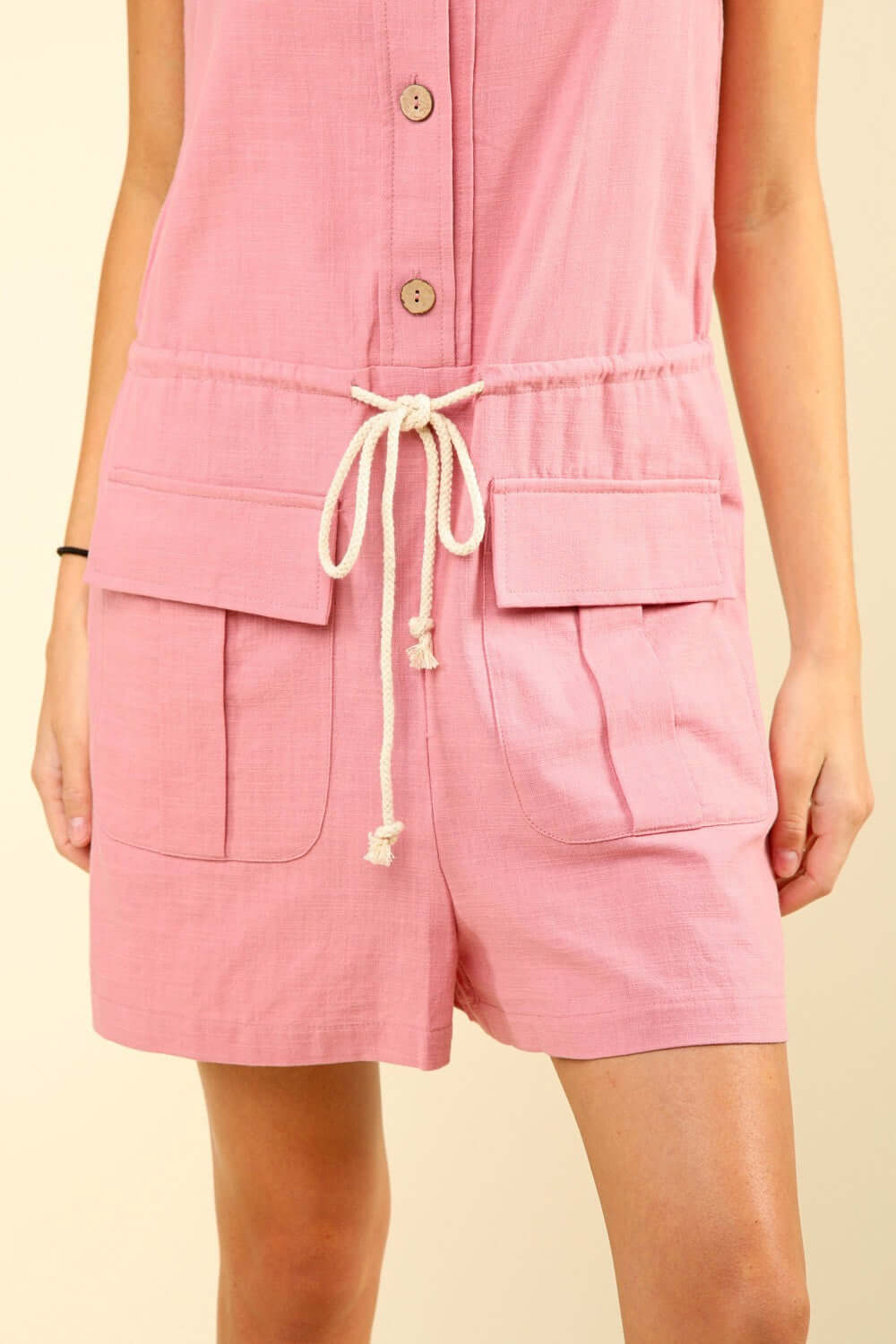 Half Button Drawstring Sleeveless Romper in pink with adjustable waist and front pockets, perfect for casual and trendy summer outfits.