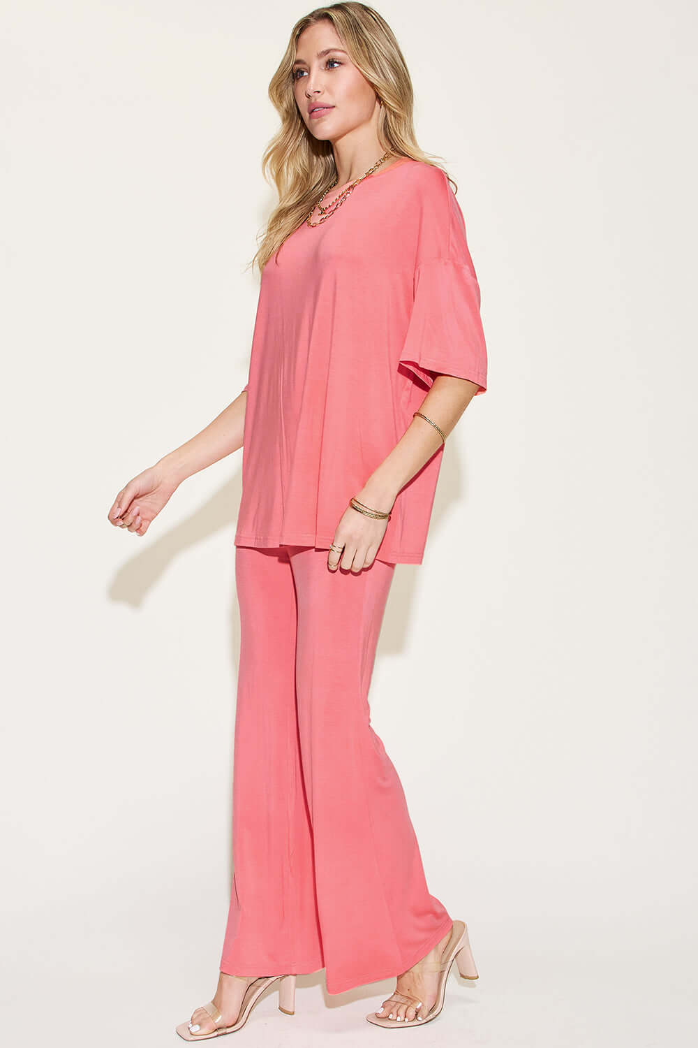 Woman wearing a pink Bamboo Drop Shoulder T-Shirt and Flare Pants Set featuring a basic style, made from bamboo fiber and spandex.