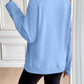 Back view of woman wearing Ivy Lane Half Zip Raglan Sleeve Sweatshirt in blue, showing pocket details and relaxed fit