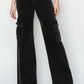 Woman showcasing high-rise wide leg cargo jeans by Risen Jeans with functional pockets and an edgy, urban style.