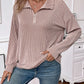 Woman wearing a striped half zip long sleeve t-shirt in a casual setting