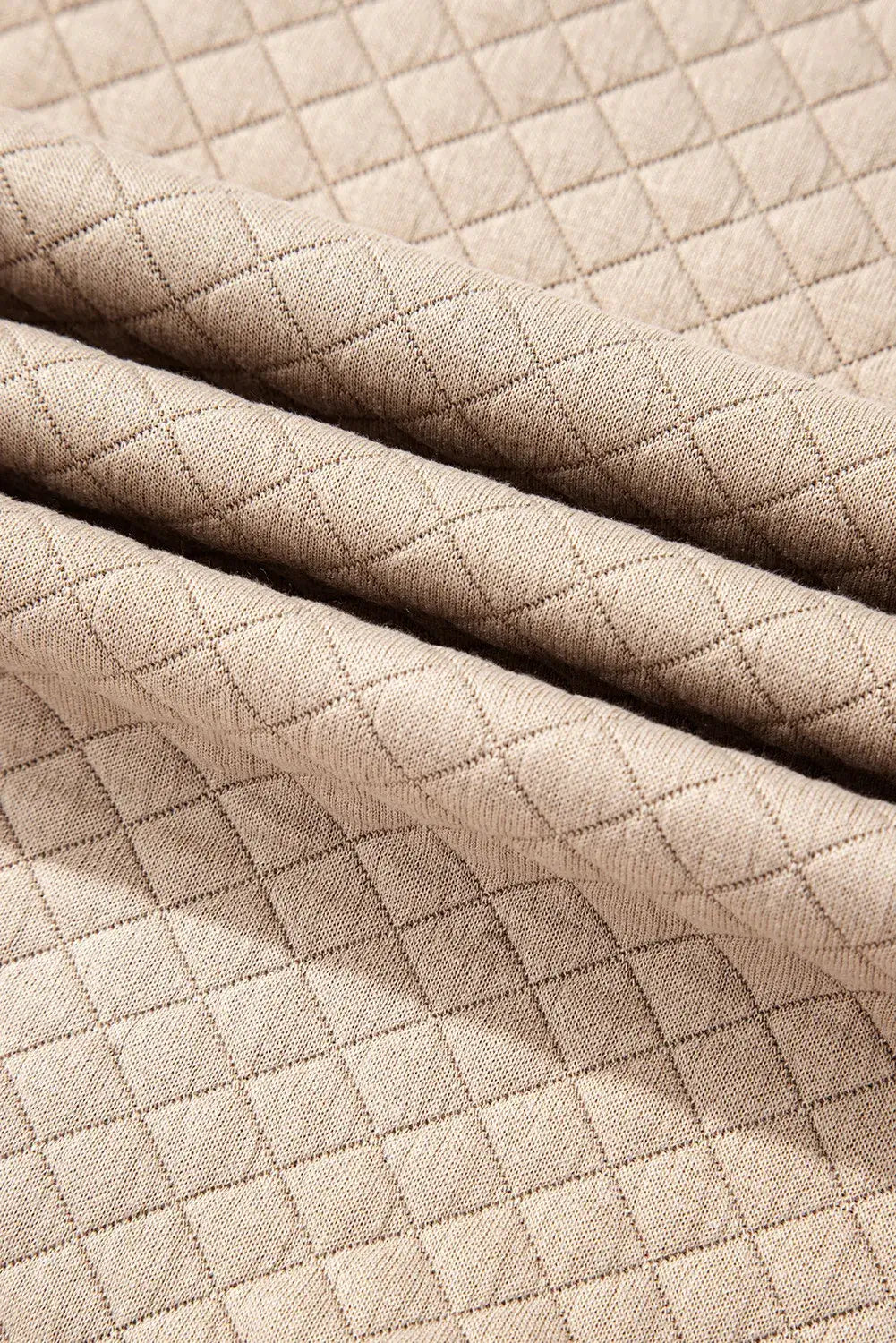 Close-up of quilted fabric texture in beige from Bella Road round neck long sleeve top and shorts set.