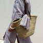 Woman wearing Bella Road Tied Button Up Three-Quarter Sleeve Dress with a woven straw bag