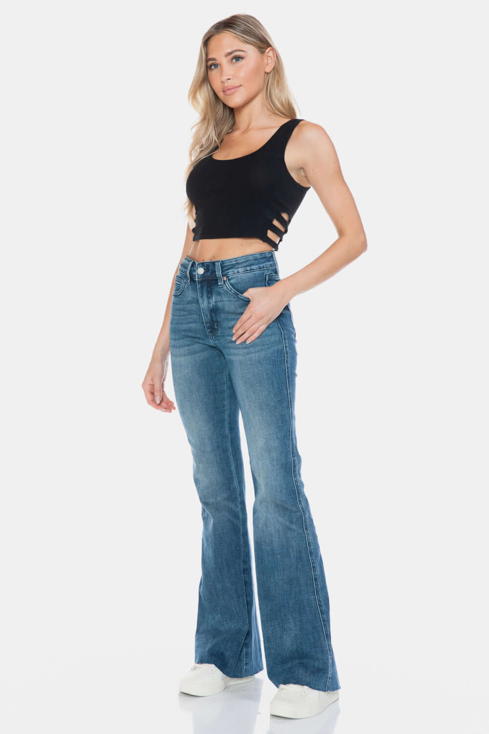 Woman wearing Judy Blue Full Size Tummy Control Cut Hem Flare Jeans, showcasing vintage wash and modern flare design.