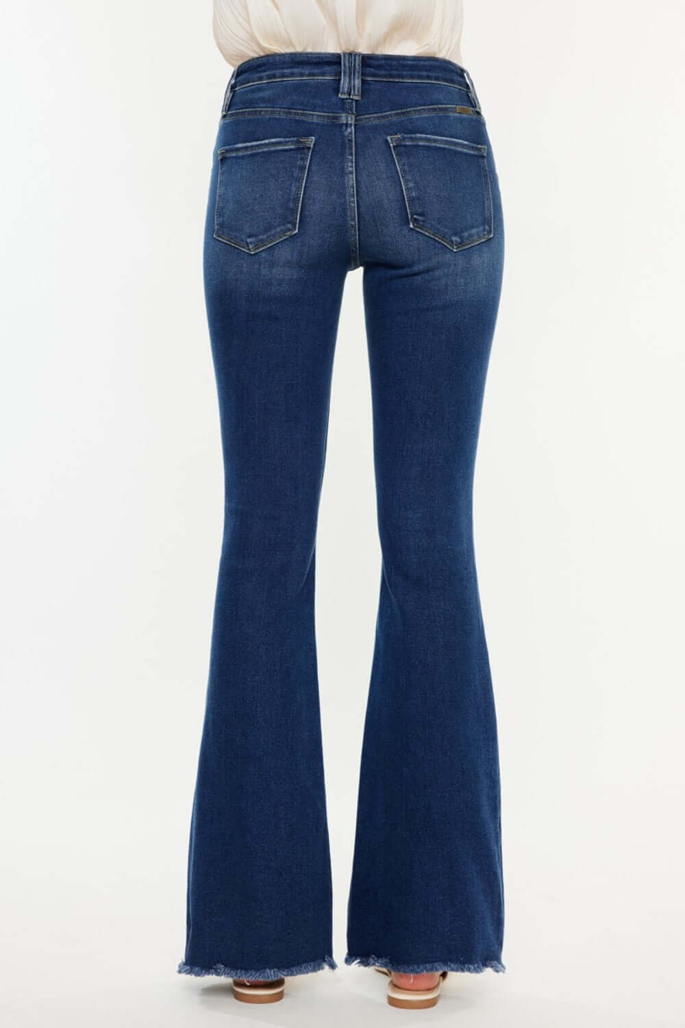 Back view of Cat's Whiskers Raw Hem Flare Jeans showcasing pocket and flare design in dark denim, perfect for a stylish retro look.