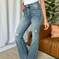 "Judy Blue medium rise tummy control destroy flare jeans with distressed details, enhancing silhouette and comfort."