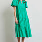 Woman wearing HEYSON green cotton poplin ruffled tiered midi dress, perfect for a stylish and comfortable warm weather outfit.