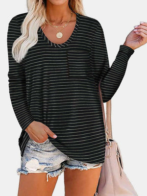 Woman wearing Bella Road Round Neck Long Sleeve T-Shirt with pocket, striped design, and distressed denim shorts, accessorized with a pink bag.