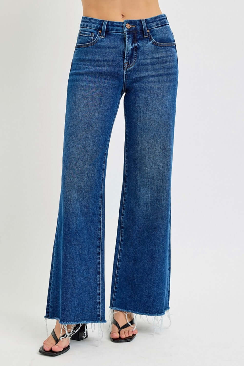 High rise wide leg jeans with tummy control, pockets, and frayed hem, styled with sandals for a chic look.