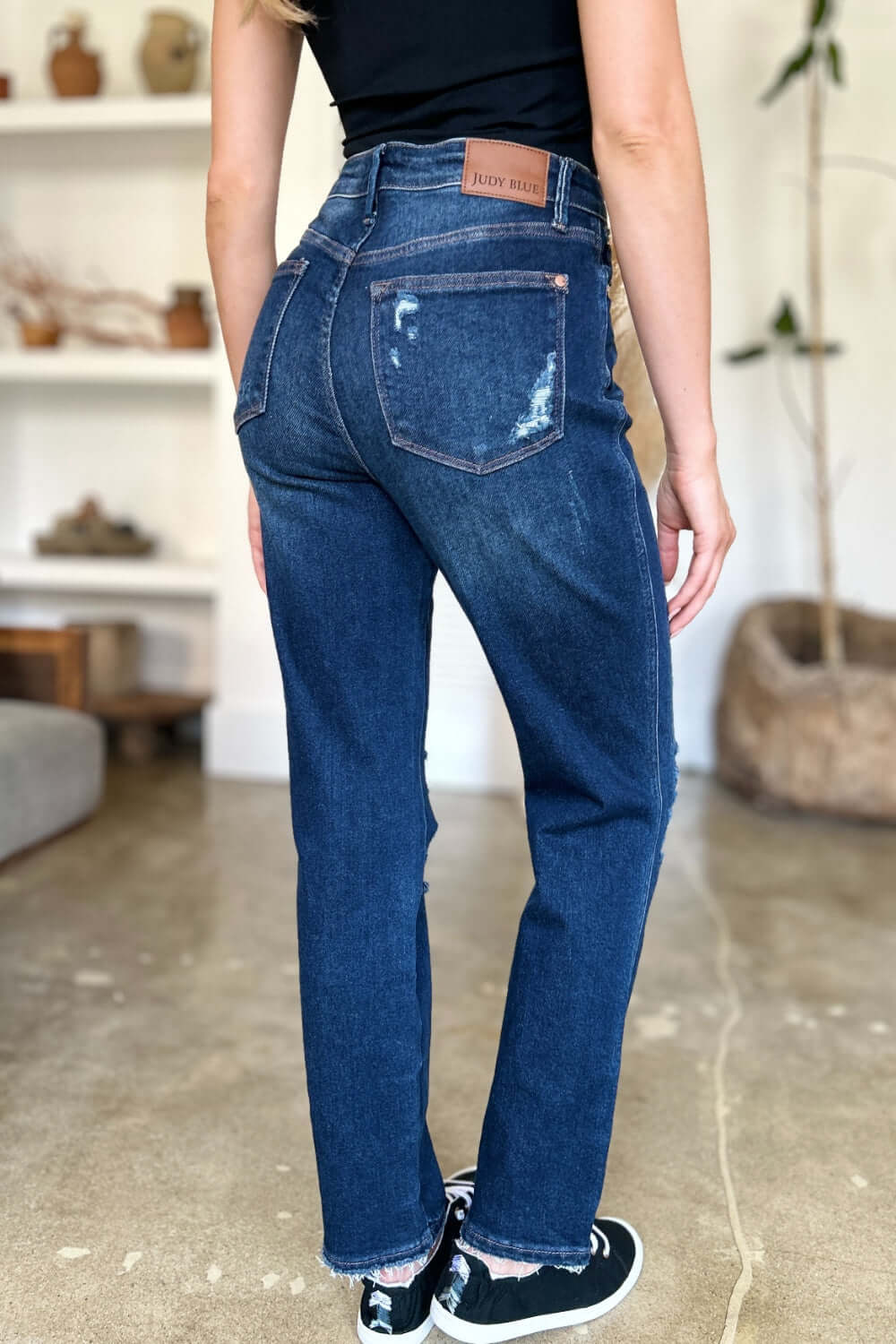 Rear view of person wearing High Waist Rigid Magic Heavy Destroy Straight Judy Blue Jeans with heavy distressing and high waist.