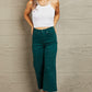 Woman wearing Judy Blue Hailey Full Size Tummy Control High Waisted Cropped Wide Leg Jeans in teal with a white tank top