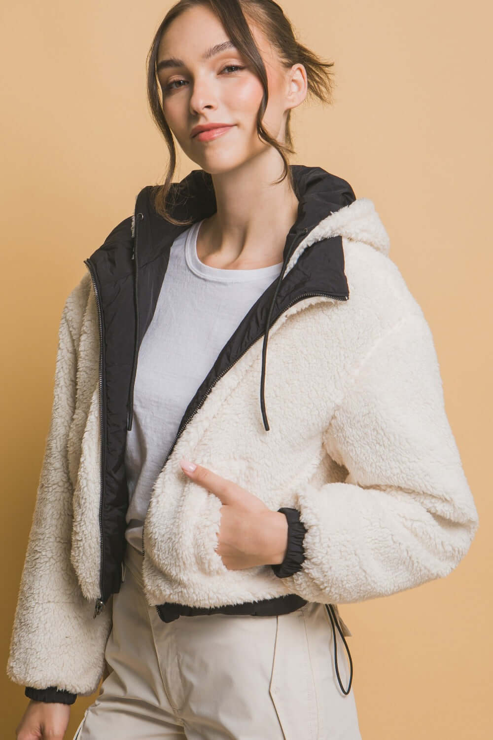 Woman wearing Love Tree Zip-Up Cropped Hooded Sherpa Reversible Jacket in cozy white, showcasing versatile and stylish outerwear.