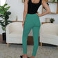 Woman wearing FAM-FAM high waist skinny pants in green, showcasing style and versatility in a chic indoor setting.