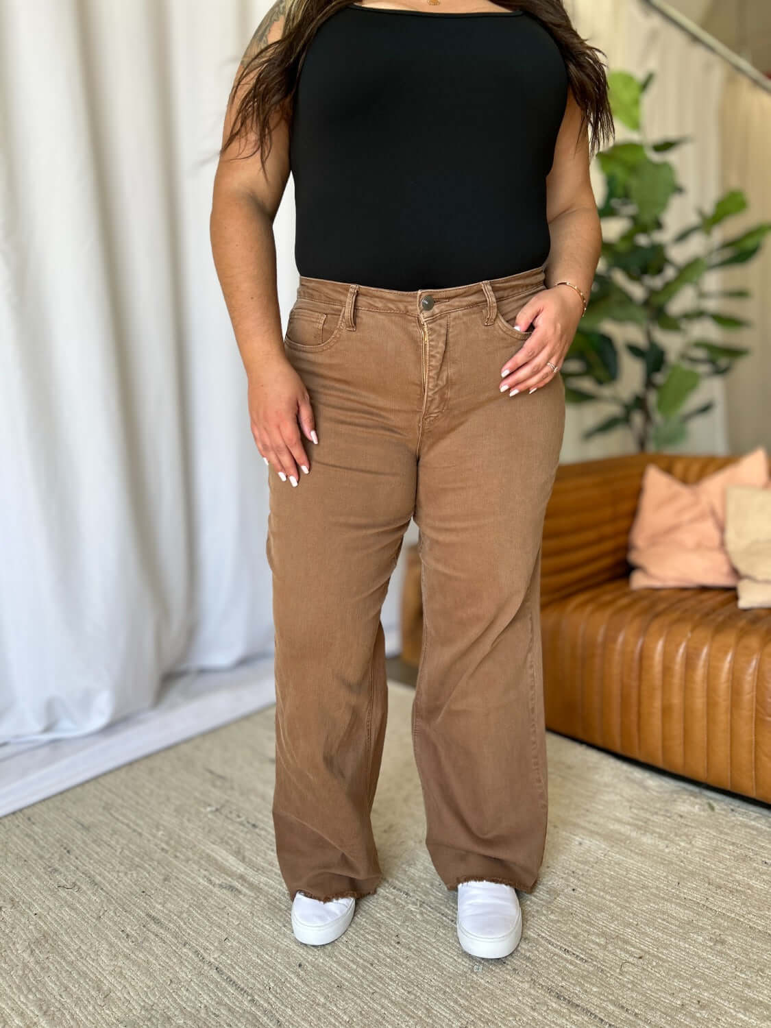 High Rise Garment Dye Wide Leg Jeans in rich brown color with a relaxed, flattering fit modeled with a black top and white sneakers.