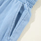 Close-up of Bella Road Drawstring Wide Leg Jeans in medium blue, showcasing the elastic waistband and soft fabric.