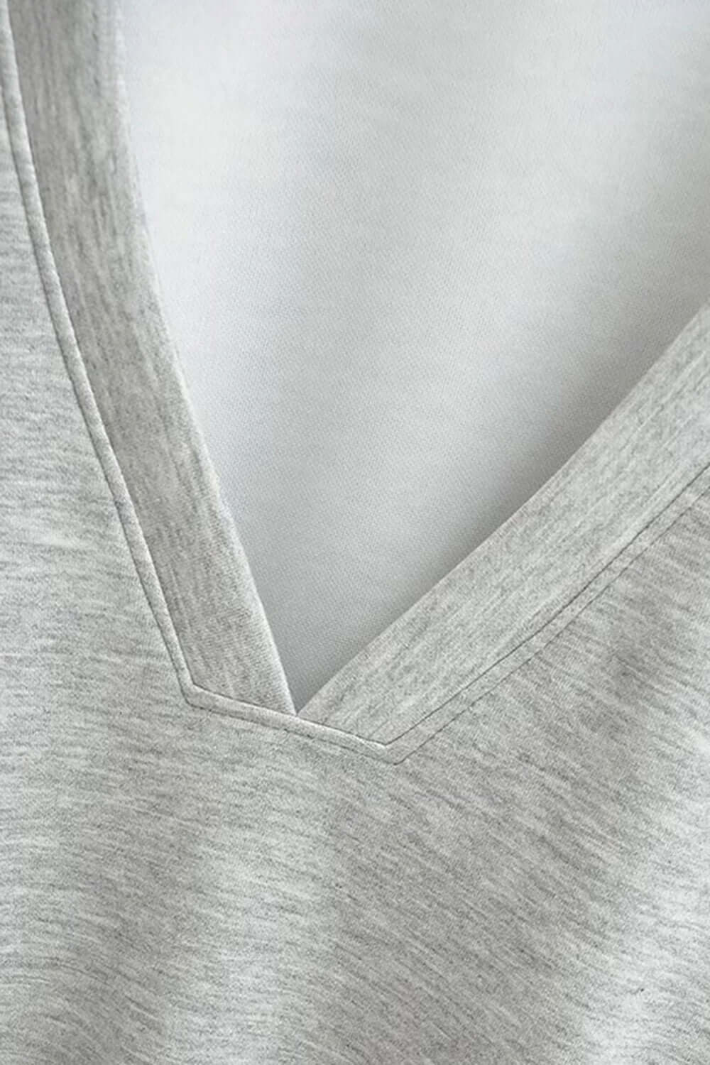 Close-up of Basic Bae V-Neck Dropped Shoulder Long Sleeve Sweatshirt with Bra showing detail of V-neck in light grey fabric