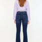 Woman wearing Kancan high-rise double waistband flare jeans in dark wash with welt pockets, stylish and versatile denim fashion.