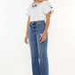 Woman wearing Kancan Full Size High Rise Slim Wide Leg Jeans in a medium wash, paired with a white embroidered top.