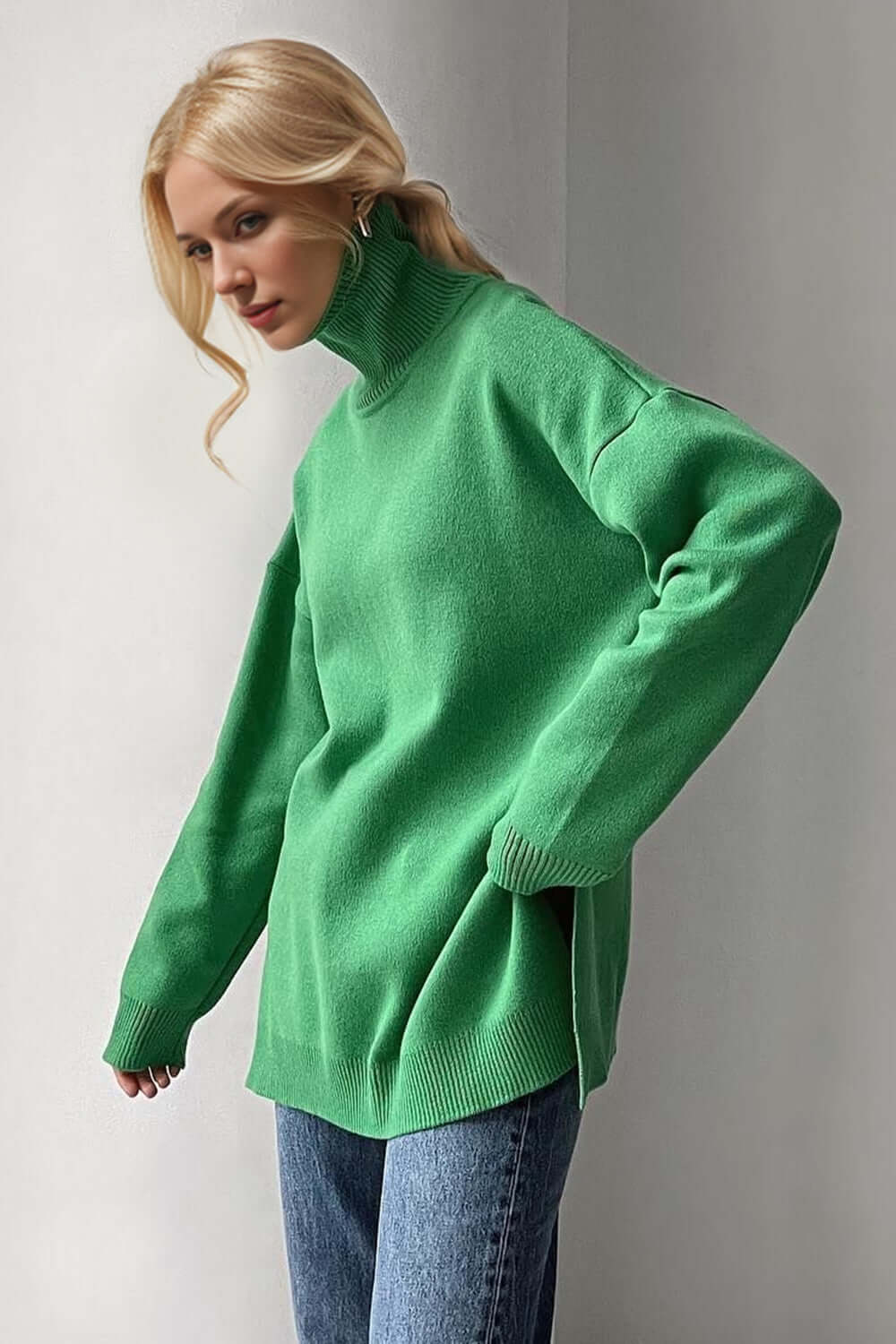 Cozy green turtleneck sweater with side slits and dropped shoulders, perfect for a stylish and comfortable look.